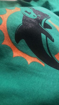 the miami dolphins logo on a green t - shirt